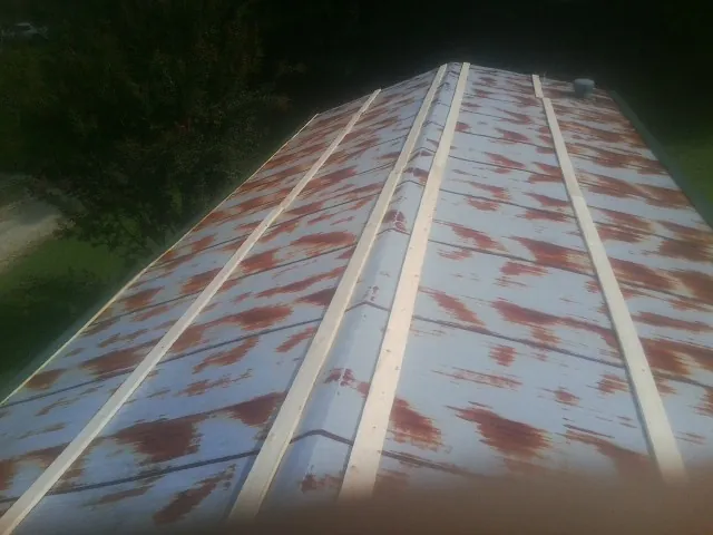 Rusted metal roof panels with new wood purlins before replacement — Storm Damage Roof Repair in Millheim by Roofing Brothers