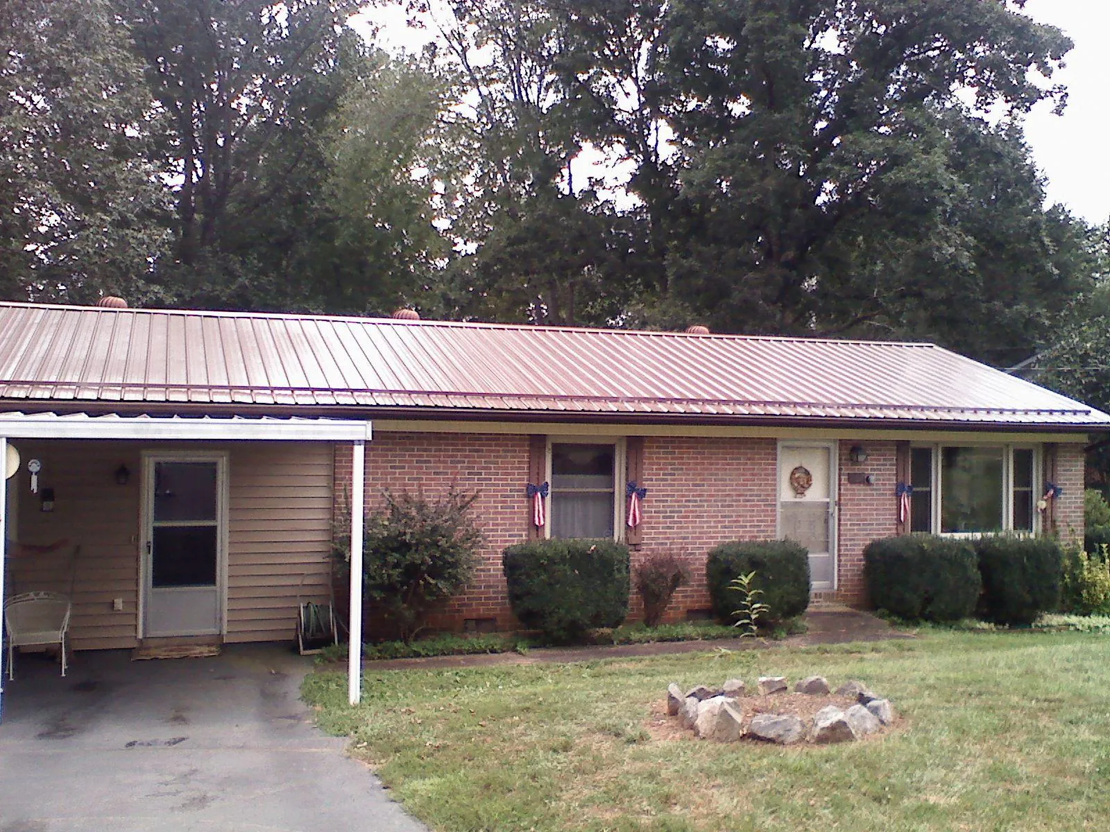 Bronze metal roof and carport on a brick ranch home — Roof Repair work by our crew in Millheim